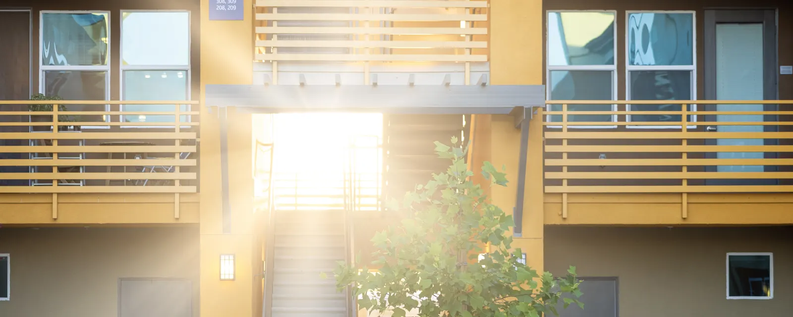 Photo d'illustration, qui ne montre pas cette structure : une cour intérieure baignée de soleil, ses coursives et une plante.