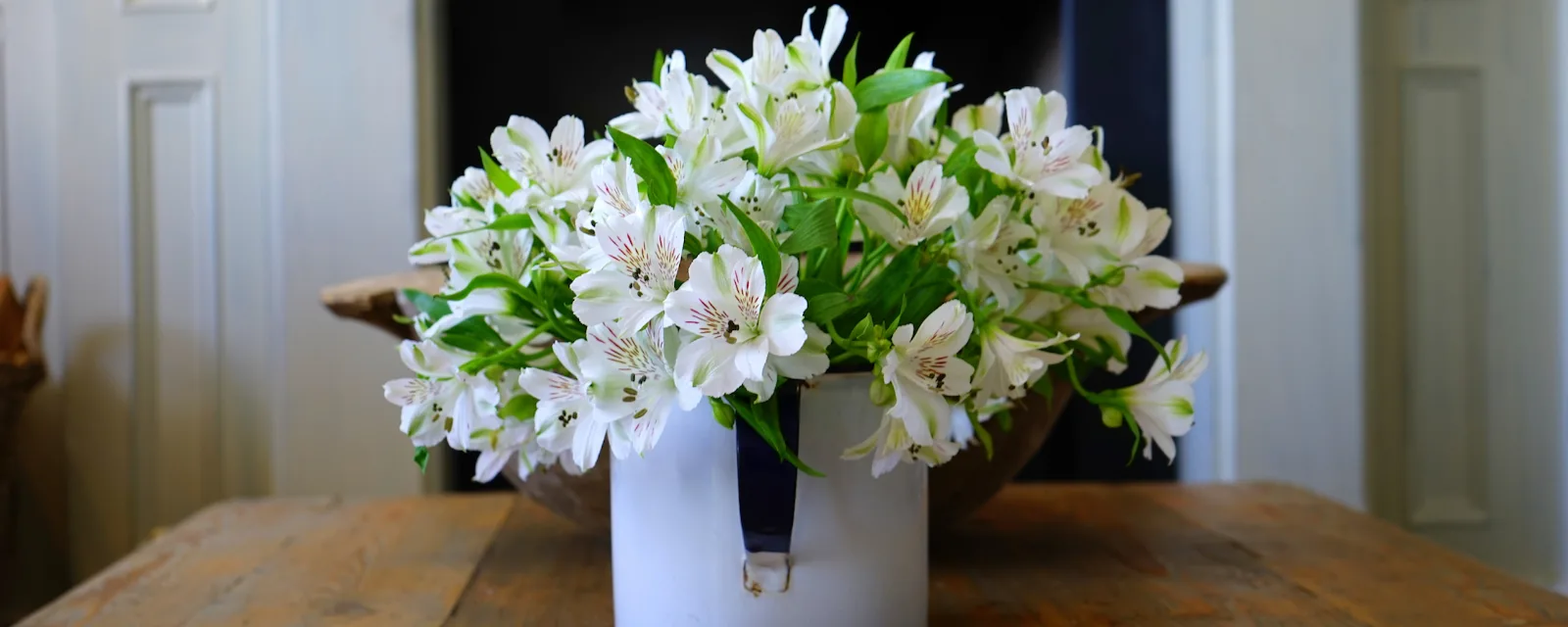Photo d'illustration, qui ne montre pas cette structure : un bouquet de fleurs blanches sur une table en bois massif.